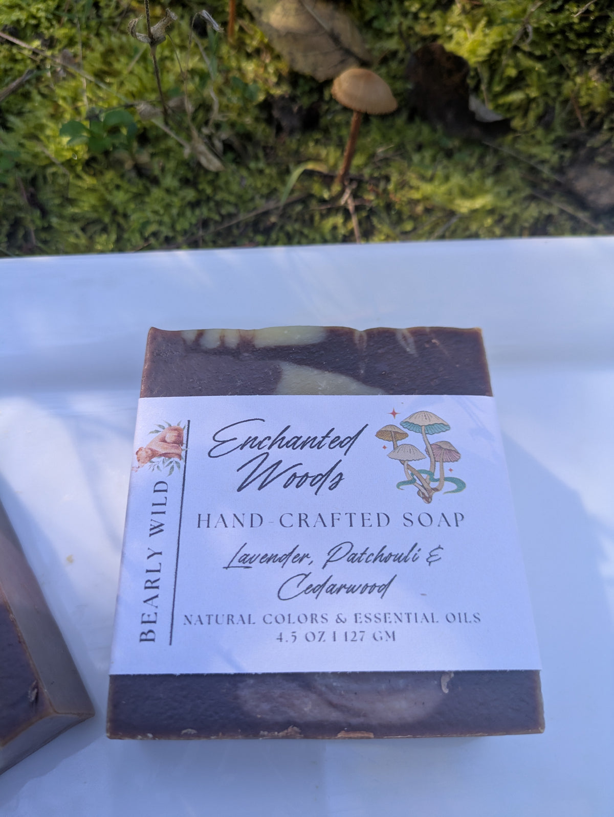 1 labeled bar of Enchanted Woods soap with moss and mushroom in the background. 