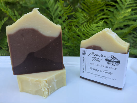 Three bars of Mountain Trail soap. Soaps are different shades of brown, looking like a mountain range, and the top features a cream color, looking like snow on top. 